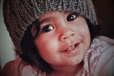 a small girl in a knitted hat