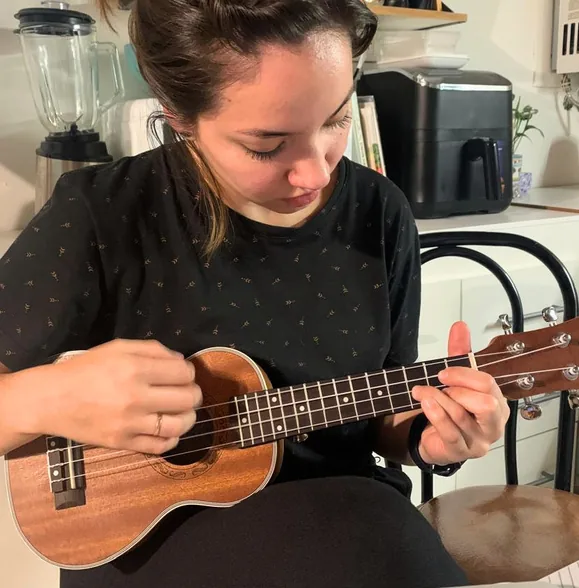 Erica playing a ukulele at the kitchen counter